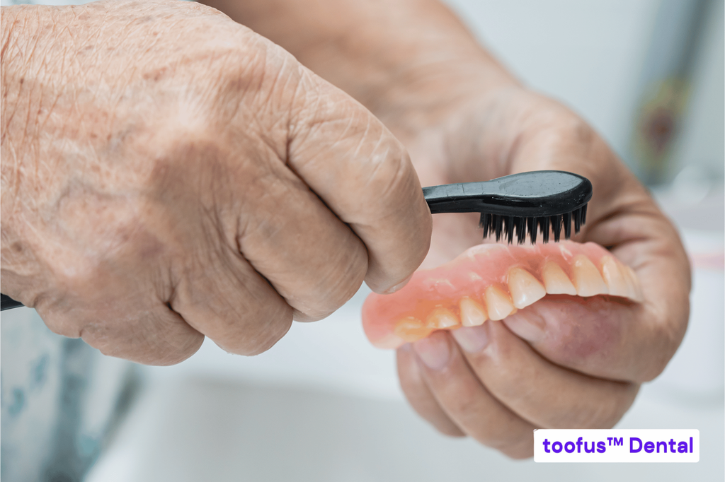 5 Questions to Ask Before Committing To Dentures 3 Senior patient gently brushing dentures – toofus™ Dental