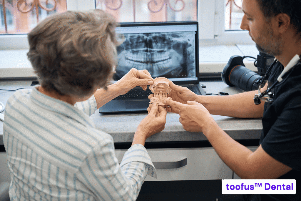 The Essential Guide: Stop Hidden Costs for Dental Implants 1 Dentist showing an elderly patient their dental x-ray and a dental model - toofus™ Dental