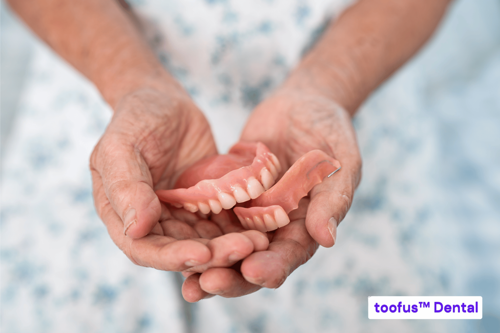 What Results Can I Realistically Expect From Dentures? 1 Senior holding removable dentures and considering expected denture results – toofus™ Dental